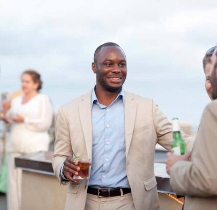 group of men standing and talking on a rooftop bar