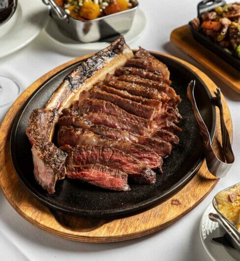 rack of ribs and other dinner dishes on white tablecloth