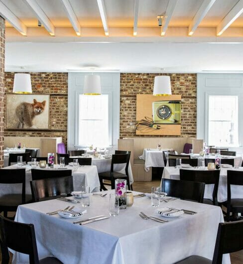 indoor dining room with brick walls and tables with white tablecloths